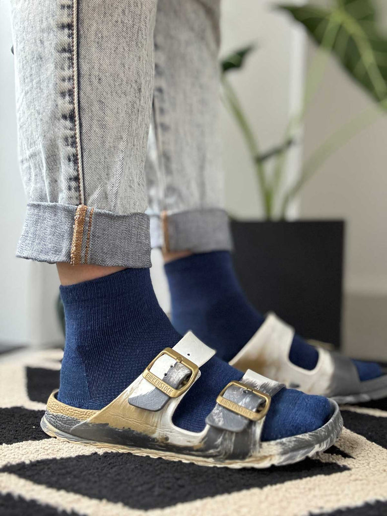 Blue merino ankle socks styled with Birkenstock sandals, casual warm-weather pairing from Merino 365