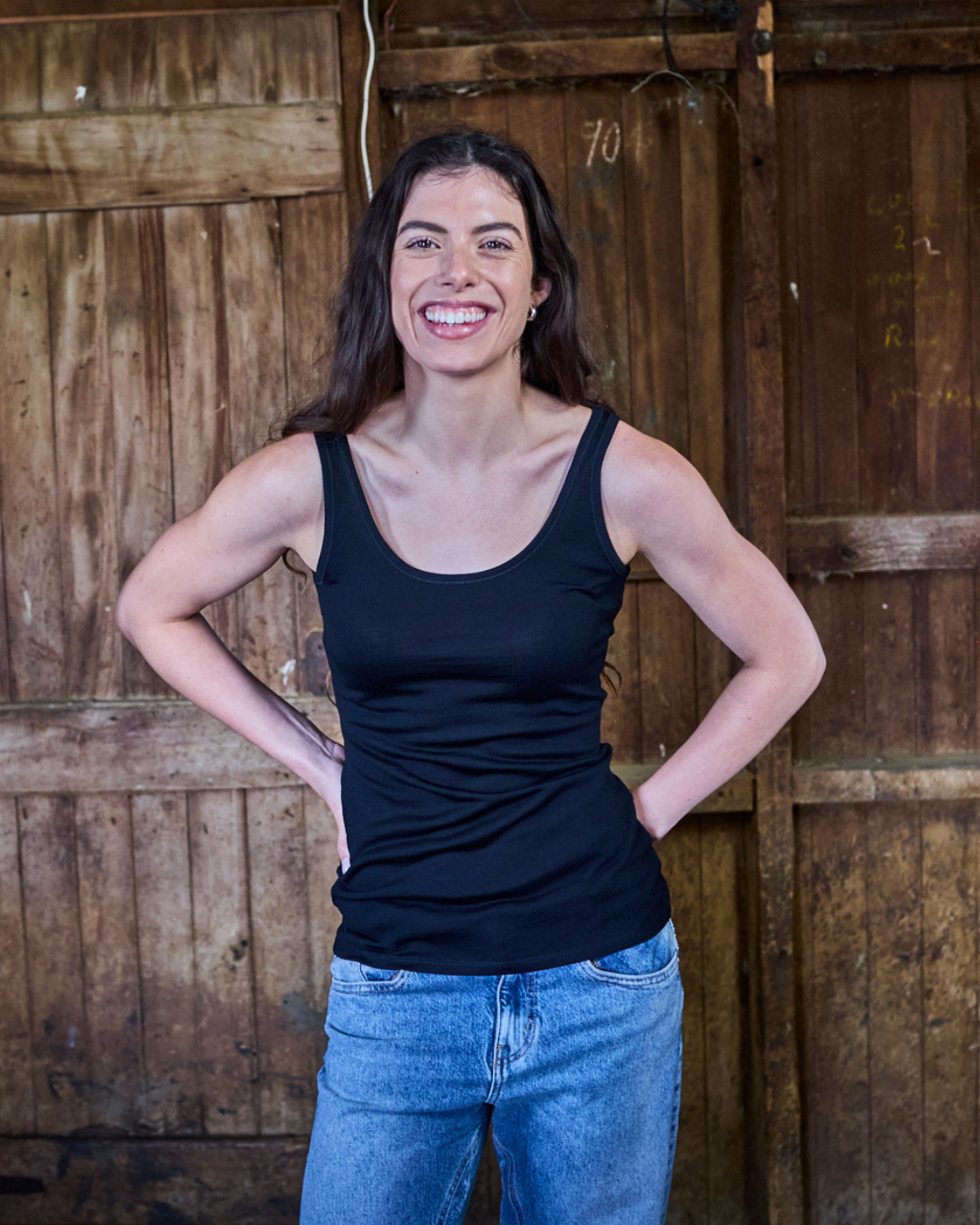 Close-up of black merino wool tank fabric β fine-gauge knit texture, soft drape, scoop neckline detail.
