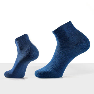 Close-up of merino ankle socks and polo collar showing fine ribbed texture and natural earthy tones