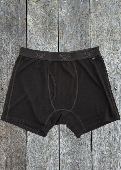 Black merino boxer brief on wood — fitted cut, soft knit, elasticated waistband, Merino 365
