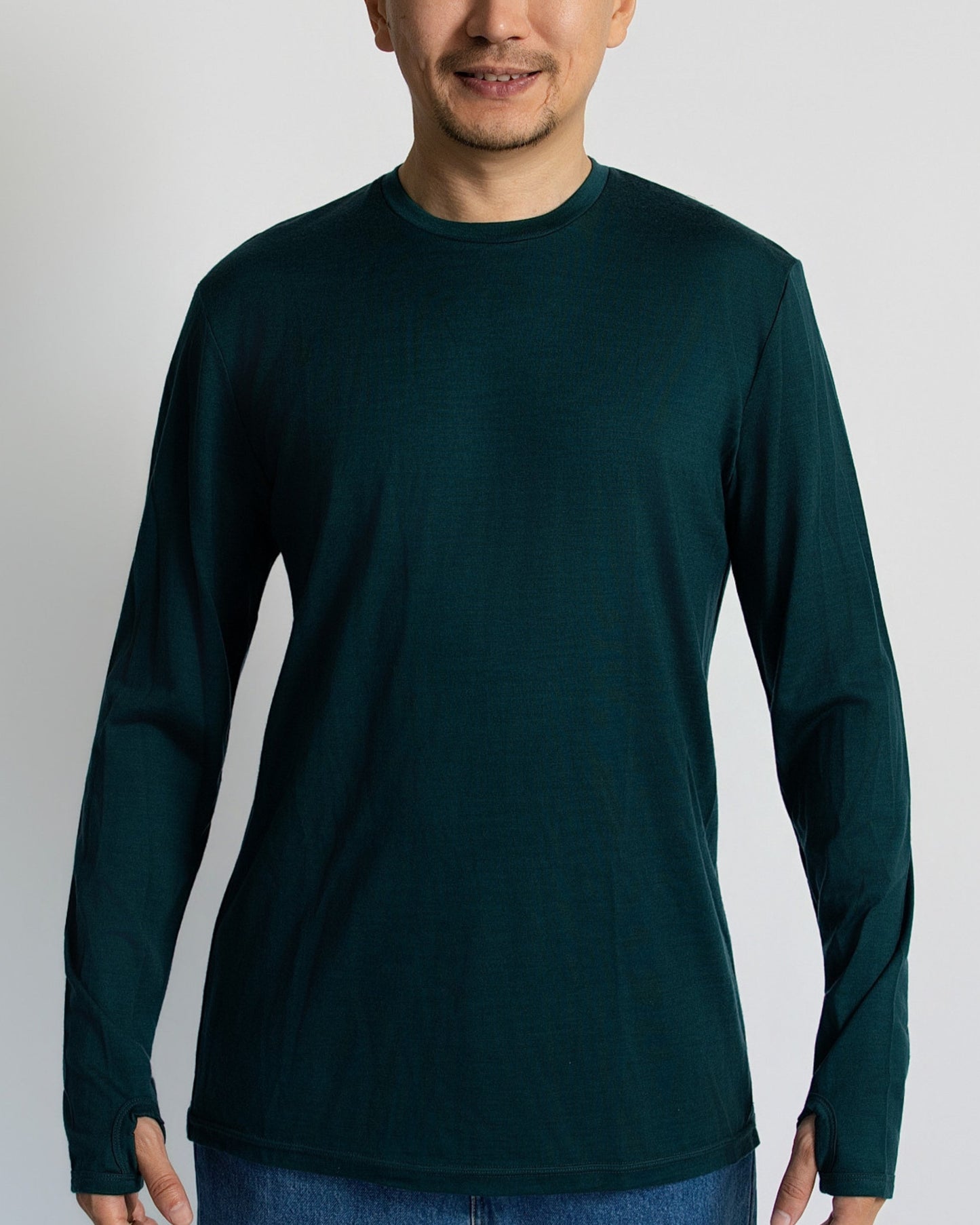 Man wearing a dark Pine green merino long-sleeve shirt against a white background