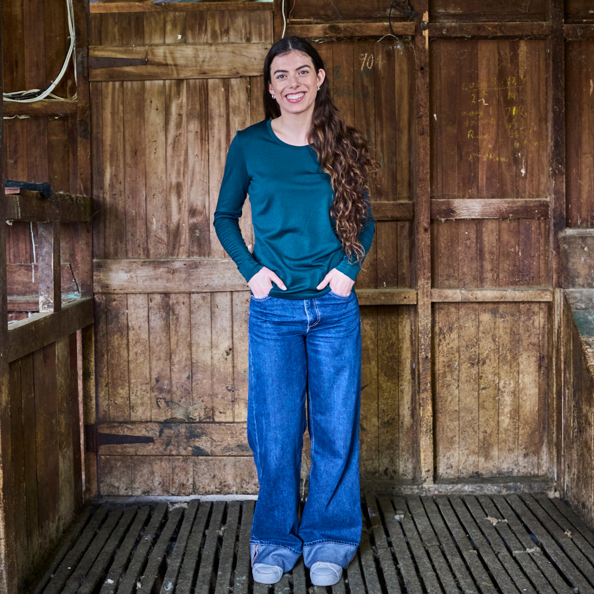 Pine green merino long sleeve top paired with matching slim pant — coordinated base layer set on model.