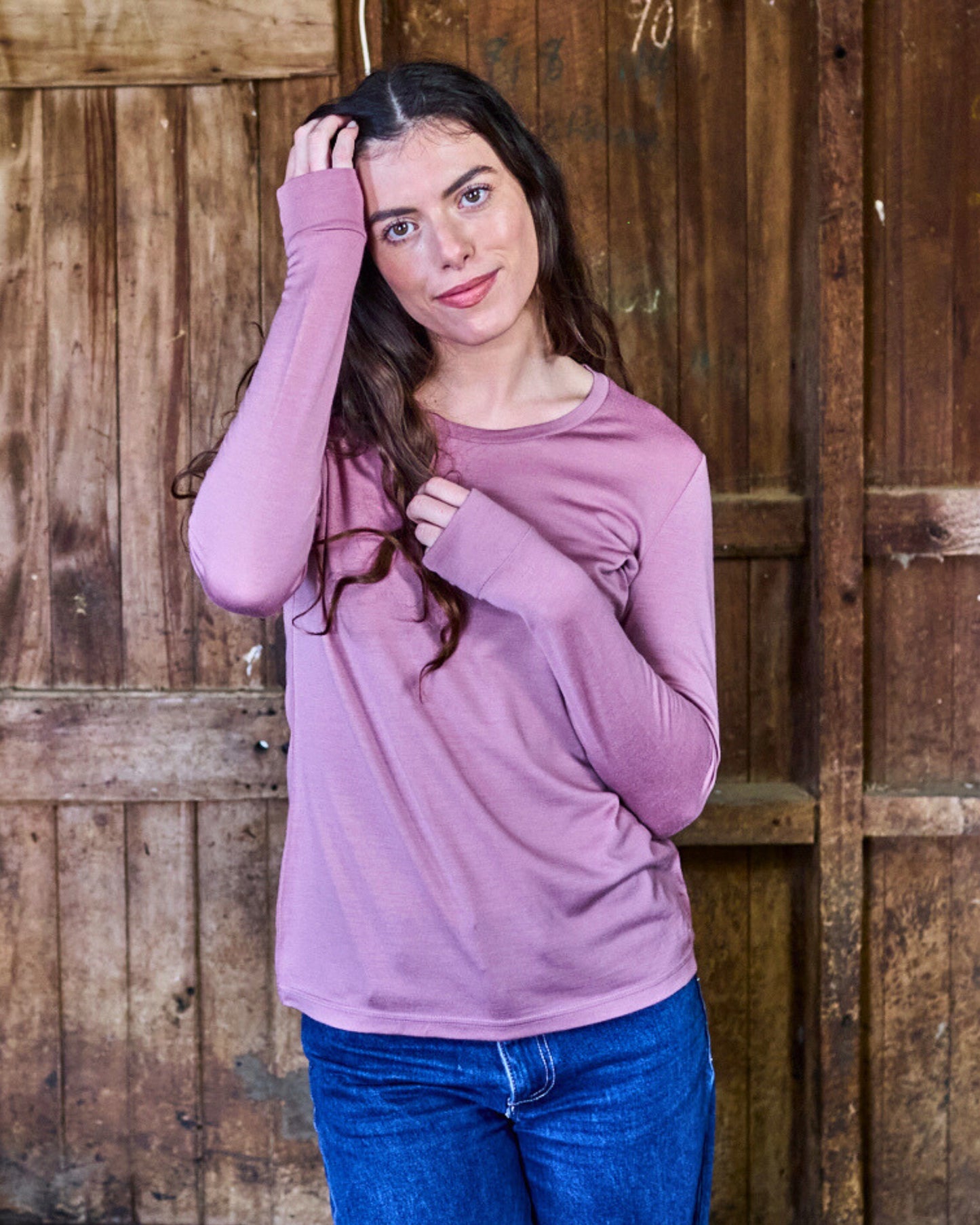 Back view of rose pink merino long sleeve top, showing clean seam lines and soft blush knit finish.