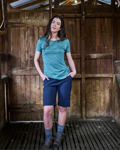 Model wearing fern green merino crew tee — earthy tone against natural outdoor setting.
